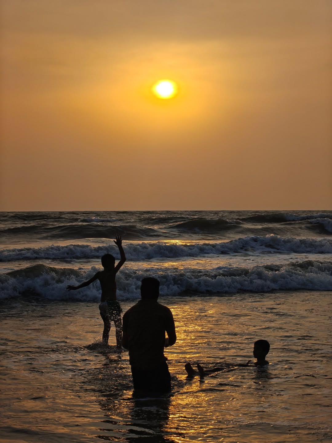 A family in the shallows at sunset